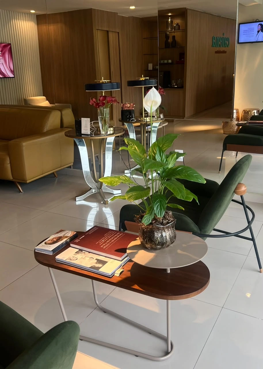 Recepção da Clínica Caiena, com poltronas, plantas e identificação da clínica